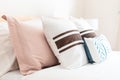 White bed with pink and blue, brown striped pillows Royalty Free Stock Photo