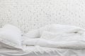 White bedding sheets and pillow in white room background. Messy bed concept in morning time Royalty Free Stock Photo