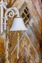 White bell for a rustic wooden door knocker