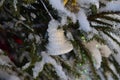 White bell on snow-covered branch of christmas tree Royalty Free Stock Photo