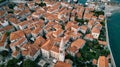 White bell tower of the Church of St. Ivan among the red roofs of the ancient houses of Budva. Montenegro. Drone Royalty Free Stock Photo