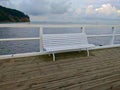 White bench on the wharf in the Sopot city in Poland during cloudy weather Royalty Free Stock Photo