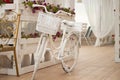 A white bicycle with a flower box stands near a summer coffee shop Royalty Free Stock Photo