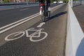 White bicycle icon symbol  and people ride bicycle on bicycle lane. Royalty Free Stock Photo