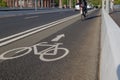 White bicycle icon symbol  and people ride bicycle on bicycle lane. Royalty Free Stock Photo