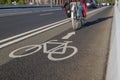 White bicycle icon symbol  and people ride bicycle on bicycle lane. Royalty Free Stock Photo