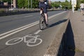 White bicycle icon symbol  and people ride bicycle on bicycle lane. Royalty Free Stock Photo