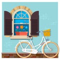 White bicycle near the building facade with a window.Street building facade of the house with bicycle. Front shop for