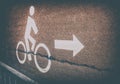 White bicycle road sign on asphalt lane with arrow symbol in vintage style Royalty Free Stock Photo