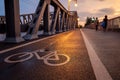 White bicycle symbol on bicycle lane beside the road on BÃÂ¶sebrÃÂ¼cke steel bridge at Bornholmer in Berlin, Germany during sunset.