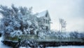 White big house surrounded by wooden fence with lush trees in a garden in winter Royalty Free Stock Photo