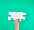 white big puzzle in female hand on green background Royalty Free Stock Photo