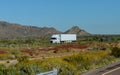 White big rig American long haul semi truck with moving on wide divided turning highway with mountain Royalty Free Stock Photo