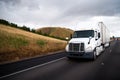 White big rig semi truck with dry van semi trailer driving in st Royalty Free Stock Photo