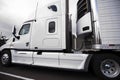 White big rig semi truck with reefer semi trailer and refrigerator unit on it running on the road Royalty Free Stock Photo