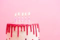 White birthday cake with red chocolate profile on pink background with five colorful lit candles. Happy Birthday party Royalty Free Stock Photo