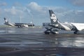 White and black Air New zealand planes parked on tarmac. at Auckland Airport after rain