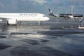 White and black Air New zealand planes parked on tarmac. at Auckland Airport after rain