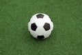 Classic ball for playing soccer in white with black accents on artificial turf, close-up view Royalty Free Stock Photo