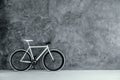 White and black bike on empty grey concrete wall