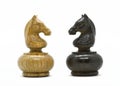 White and black chess knights stands opposite each other on white background Royalty Free Stock Photo