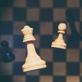 White and black chess pieces falling on the chessboard. The concept of turning a pawn into a queen Royalty Free Stock Photo