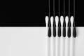 White and black cotton swabs are symmetrically arranged opposite each other. Royalty Free Stock Photo