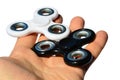 White and black fidget spinner toys held in palm of adult male person, white background