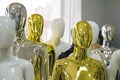 White, black, golden, silver mannequins stand in a row one after another. Concept of a faceless crowd.