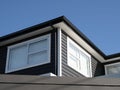 a white, black and gray house with two windows on the front of the house Royalty Free Stock Photo