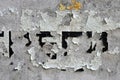 White black grey wall, floor with cracks and remains of pasted paper with unknown text, texture background
