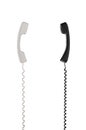 White and black handsets are arranged vertically towards each other. Royalty Free Stock Photo