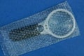 White black magnifier in a plastic bag Royalty Free Stock Photo