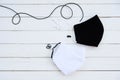 A white and black muslin cloth mask placed on a wooden table Use