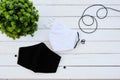 A white and black muslin cloth mask placed on a wooden table Use