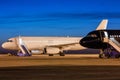 White and black passenger airplanes on the apron of the airport at dusk