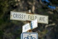 White and black road sign that say Crissy field avenue and mason street with bicycle on post near road in downtown city