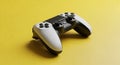 A White and Black Video Game Controller on a Vibrant Yellow Background gaming gamepad Royalty Free Stock Photo