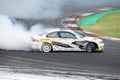 White black yellow BMW E46 producing smoke on a trail for a drift competition