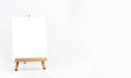 White blank artist frame on a small wooden easel on white background.
