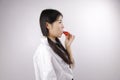 Close up white blank background Asian Chinese girl young woman is eating fruit Strawberry healthy balanced life Royalty Free Stock Photo