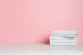 White blank books on white shelf and soft pink wall as modern, elegant home decor.