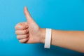 White blank bracelet on hand. Music festival branding wristband, adhesive paper accessory