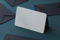 White blank business card and black envelopes on dark background. 3d rendering.