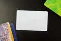 White blank business card. Office desk with set of colorful supplies, cup, pen, pencils, flower, notes, cards on black Royalty Free Stock Photo