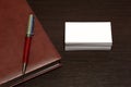 White blank business cards with place for text notepad with pen on a dark table. Business business set