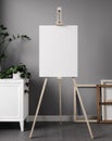 White blank canvas on wooden easel, in minimal living room interior. 3d rendering Royalty Free Stock Photo