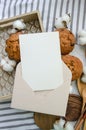 White blank card with beige envelope, homemade muffins, wooden tray, wooden dishware, cotton buds. Recipe or cook book, food menu
