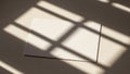 White blank card casting shadow patterns from window blinds on a surface Royalty Free Stock Photo