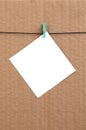 White blank card on rope on a brown cardboard background. Creati Royalty Free Stock Photo